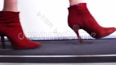 苗条的女人`穿着红色<strong>靴子</strong>的腿，穿着细<strong>高跟</strong>鞋走在T台上，展示了一系列新的鞋子